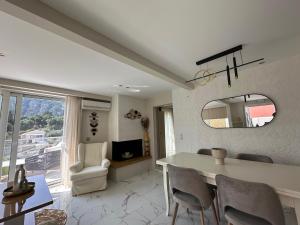 a living room with a table and chairs and a mirror at Tango Sunset Villa in Paleokastritsa
