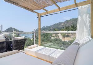 a balcony with a bed and a view of the ocean at Tango Sunset Villa in Paleokastritsa