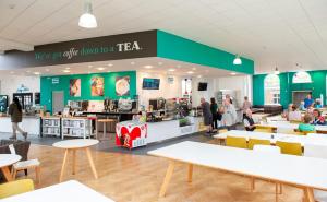 een restaurant met tafels en mensen in een winkel bij Villas at Park Campus in Cheltenham