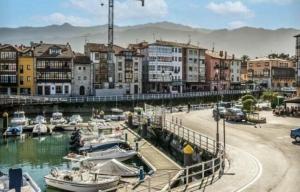 eine Gruppe von Booten, die in einem Yachthafen mit Gebäuden angedockt sind in der Unterkunft Apartamento con calefacción, balcón y hermosas vistas in Posada de Llanes + 36 Fotos