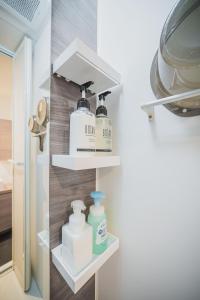 東京にあるERIKO HOTEL Azabujubanの石鹸や洗剤が置いてあるキッチンの棚