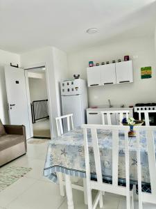 a kitchen with a table and a kitchen with a refrigerator at Praia e Sol em Caiobá! in Matinhos
