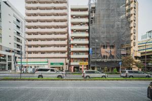 東京にあるERIKO HOTEL Azabujubanの高層ビルの前に停車した車2台