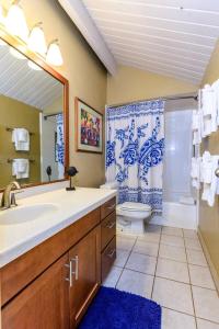 a bathroom with a sink and a toilet and a mirror at Hale Mahina B401 · HM B401 OceanFront 2BD Tropical Getaway in Kahana