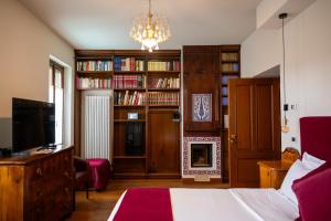 a bedroom with a bed and a fireplace and book shelves at 1448 Antica Dimora Al Merlo Bianco in Cividale del Friuli