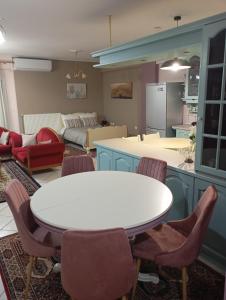 a kitchen and living room with a white table and chairs at JULIA'S APARTMENT in Igoumenitsa