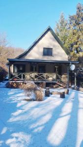 a house with snow in front of it at Kispatak Erdei Ház in Verőce