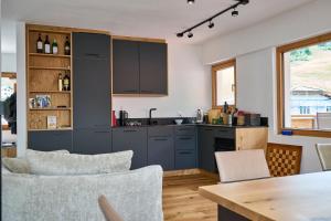 a kitchen with blue cabinets and a table and chairs at Bergnest 4 in Bivio +4 photos