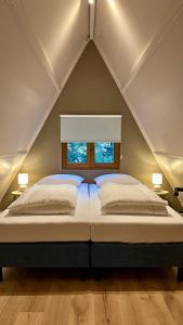 a bedroom with a large bed with a window at Boshuisje Rekem - Sylva in Lanaken