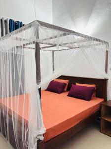 a bed with a canopy in a room at The Pearl Heaven in Dickwella