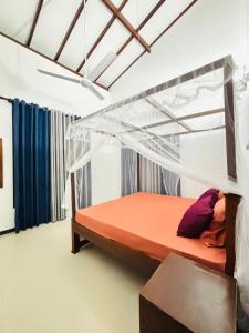 a bedroom with an orange bed with a canopy at The Pearl Heaven in Dickwella