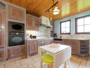 a large kitchen with wooden cabinets and a white island at Magnificent Villa in Brisy with Sauna Roofed Terrace and BBQ in Brisy