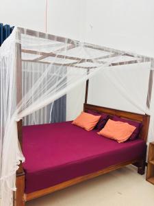 a bed with a canopy in a room at The Pearl Heaven in Dickwella