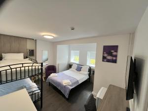 アバーデアにあるDare Valley Accommodation and Campsiteの二段ベッド2台と机のある寝室 +3枚の写真