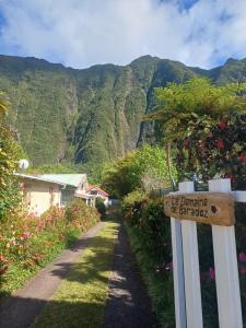 a sign on a fence with mountains in the background at Lit simple en chambre partagée au Domaine de Baradoz in La Plaine des Palmistes +8 photos