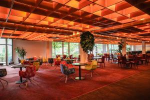 ハンブルクにあるBettenburg Hotelのテーブルと椅子と窓のある広い部屋