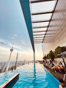 a infinity pool on the top of the shard with people sitting on the chairs at Platinum Grand Stay Kuala Lumpur in Kuala Lumpur