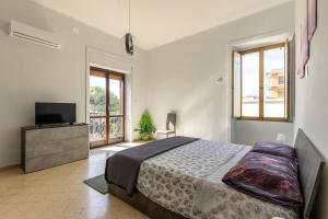 een slaapkamer met een bed en een flatscreen-tv bij Domus Angelina Pompei in Pompei +29 foto's