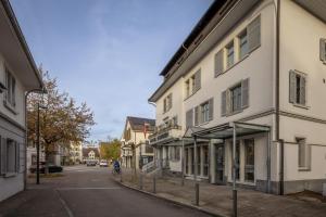 ウスターにあるHotel Ochsenの建物の横の通りをバイクで下る者