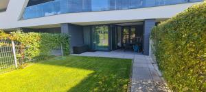 a house with a yard with a fence and grass at LAKE MOMENTS - Ruby Garden Apartment in Balatonszemes +9 photos
