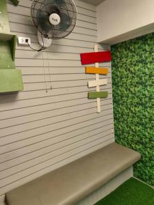 een kamer met een muur met een ventilator en een bank bij โรงแรม เลิฟ บีเคเค in Amphoe Phra Khanong