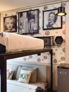 a bedroom with a bunk bed with pictures on the wall at โรงแรม เลิฟ บีเคเค in Amphoe Phra Khanong