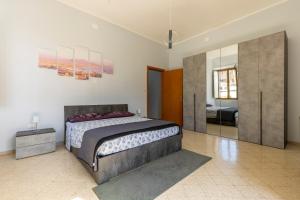een slaapkamer met een kingsize bed en een spiegel bij Domus Angelina Pompei in Pompei