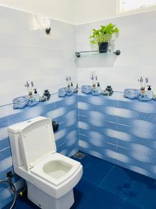 a bathroom with a white toilet and blue tiles at New Arch Heaven Ella in Ella
