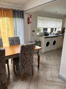 a kitchen with a wooden table and chairs at On The Common in Cardiff