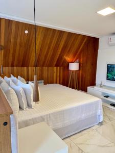 グラマドにあるHotel Locanda Casa D'Oroの白いベッド1台が備わる木製の壁のベッドルーム1室