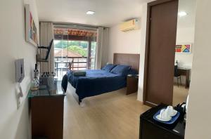 a bedroom with a blue bed and a balcony at Casa Indaiá in Petrópolis