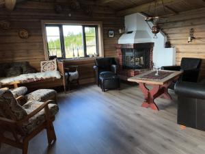 a living room with a fireplace in a log cabin at Løstegård hytter at the top of Golsfjellet in Gol