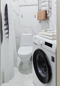 ein Badezimmer mit Waschmaschine und Toilette in der Unterkunft Белая студия Вокзал Харьков-Пассажирский in Kharkov
