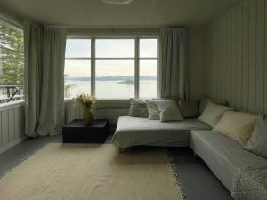 a living room with a bed and a large window at Romantic Summer House On Orust in Stillingsön