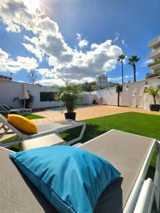 eine Terrasse mit einem Tisch, Stühlen und einer Liegewiese in der Unterkunft Bungalows Teresa in Playa del Ingles