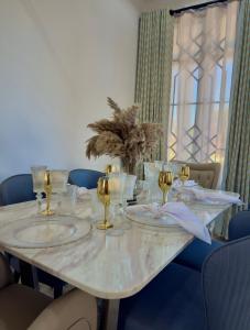 a table with plates and glasses on top of it at SC Luxury Home in Dar es Salaam