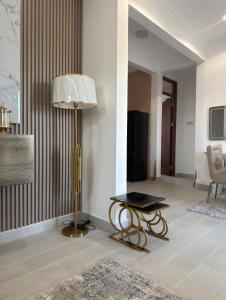 a living room with a lamp and a table at SC Luxury Home in Dar es Salaam