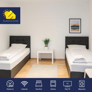 2 camas en una habitación con una mesa entre ellas en SUNNYHOME Monteurwohnungen und Apartments in Weiden, en Weiden