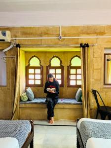 a man sitting on a bench in a train room at Little Jaisal - Boutique Hotel in Jaisalmer