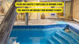 Una piscina con un cartel delante en Le Gîte du Moulin - Piscine Intérieure, en Sainte-Maure