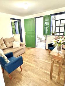 a living room with green doors and a couch and a table at Casa Charmosa no Centro Histórico in Ouro Preto