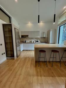 cocina con armarios blancos y suelo de madera en Zafra Chalet, en Poiana Ţapului 17 fotos más