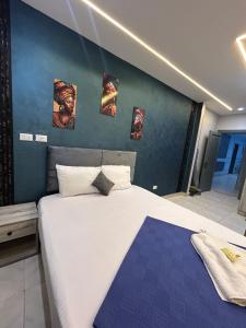 a bedroom with a large bed with pictures on the wall at Garden City Hotel In Downtown in Cairo