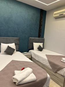 a bedroom with two beds with towels on them at Garden City Hotel In Downtown in Cairo