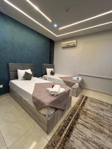 a bedroom with two beds and a rug at Garden City Hotel In Downtown in Cairo