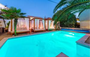 a swimming pool in front of a villa at Beautiful Apartment In Sukosan in Sukošan