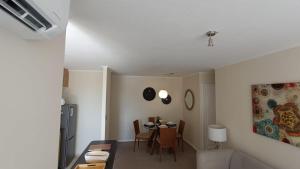 a living room with a table and a dining room at Depto en condo, 1D 1B, aire estacionamiento, full in Curicó