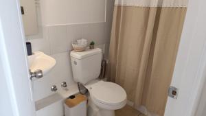 a bathroom with a toilet and a sink and a shower at Depto en condo, 1D 1B, aire estacionamiento, full in Curicó +23 photos