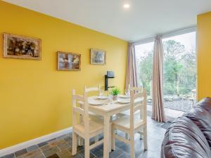 a dining room with a white table and chairs at Dutch Barn Two - Uk12873 in Brynkir