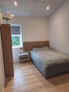 a bedroom with a bed and a window at Holiday Idyll With Nature And City Nearby in Skødstrup
